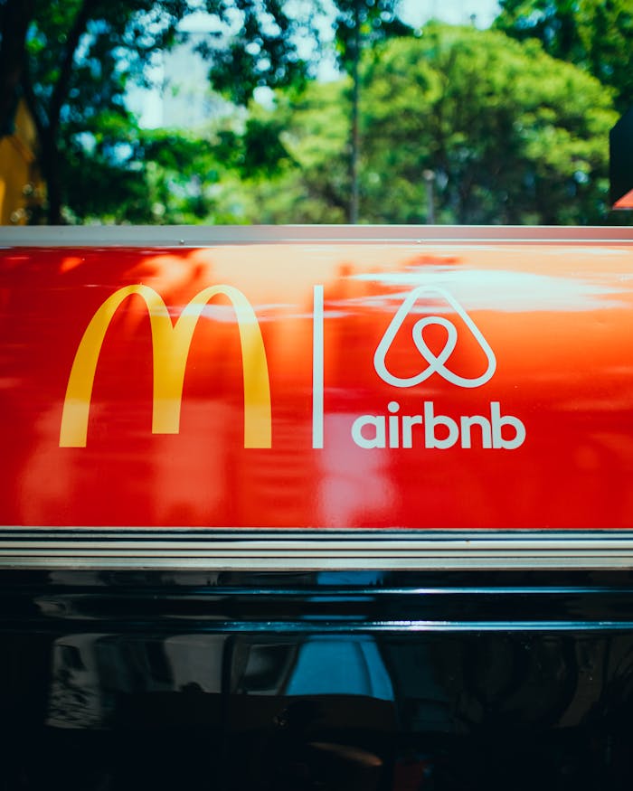 Home Bright sign showcasing recognizable logos on a vehicle's roof with blurred trees in the background.