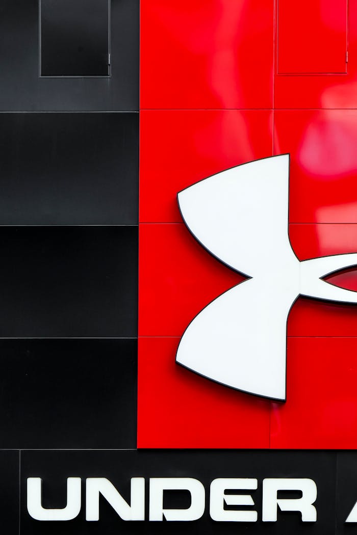 Home Close-up of Under Armour logo on a stylish red and black wall with modern graphic design elements.